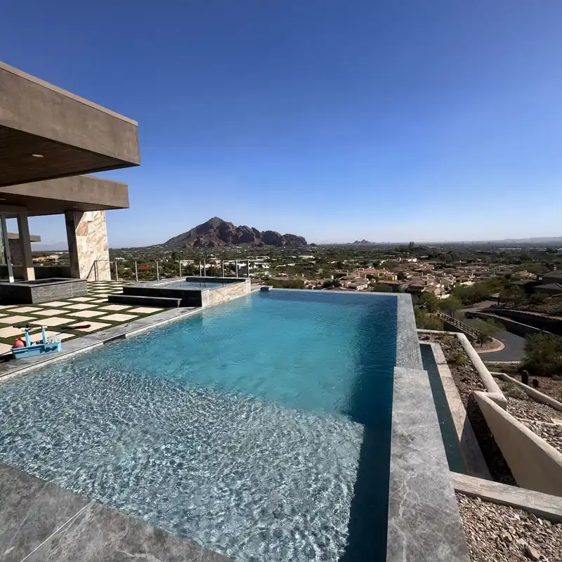 Vanishing-edge pool with a raised spa and Camelback Mountain beyond