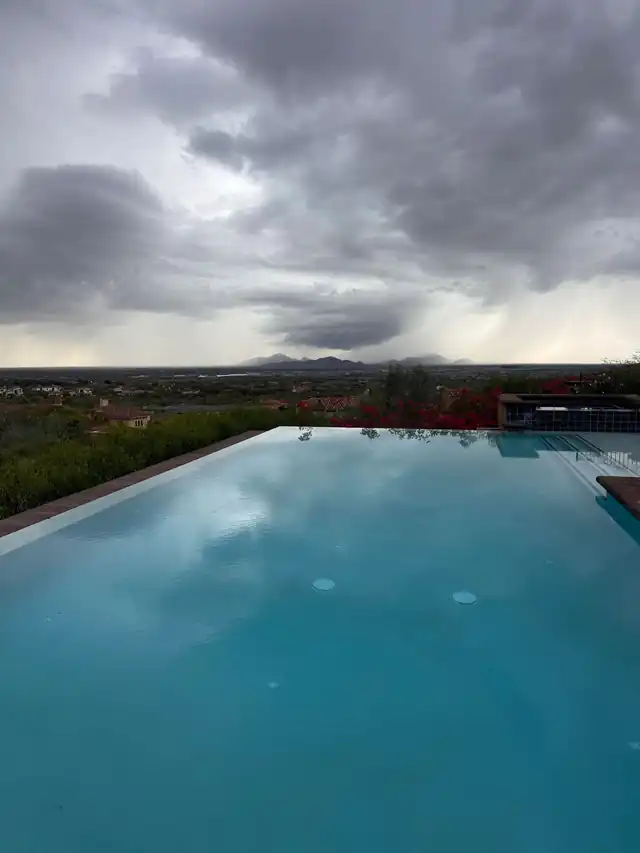 Flat pool water mirroring a storm sky
