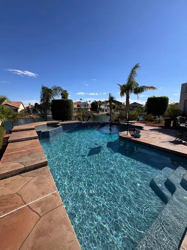 Flagstone pool with palms and a view of the water beyond